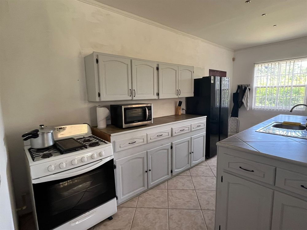 Kitchen with a gas cooker, microwave and full-height fridge