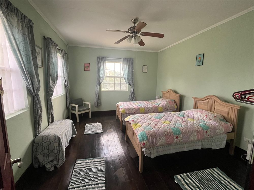 Green twin bedroom with two single beds and patchwork quilts